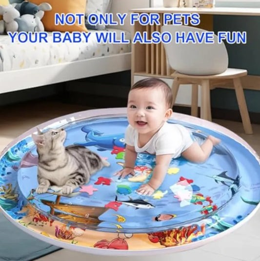 Baby playing on a colorful play mat with a cat, surrounded by toys and furniture.